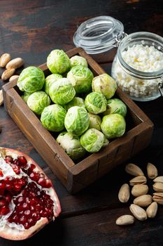 Brussels sprouts with pomegranate, cottage cheese and pistachios, on old wooden table
