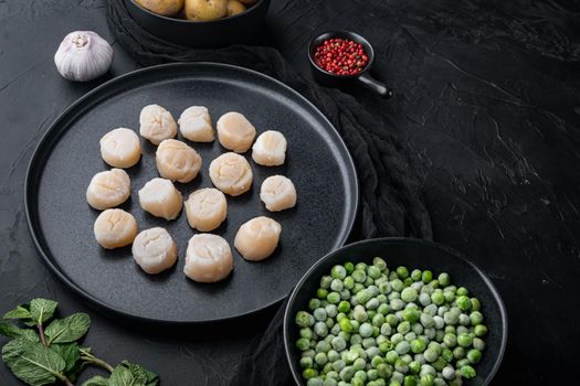Fresh seafood scallops with herbs and vegetables, on black textured background with space for text