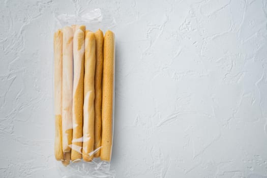 Breadsticks, with olive oil, on white background, top view with copy space for text