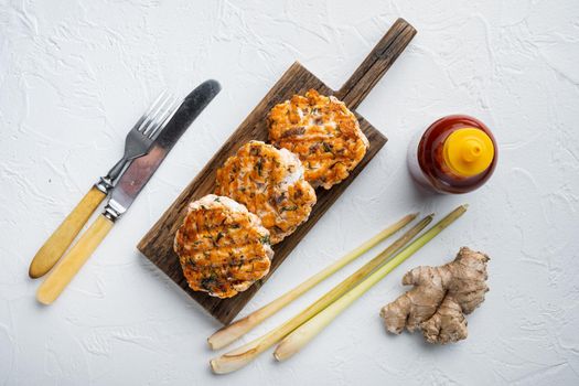Grilled quick asian fishcakes from salmon and spicy herb, on white textured background, top view