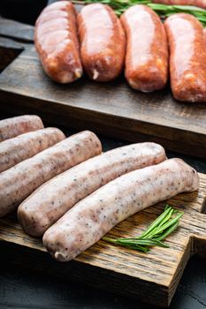 Chicken sausages, on black background.