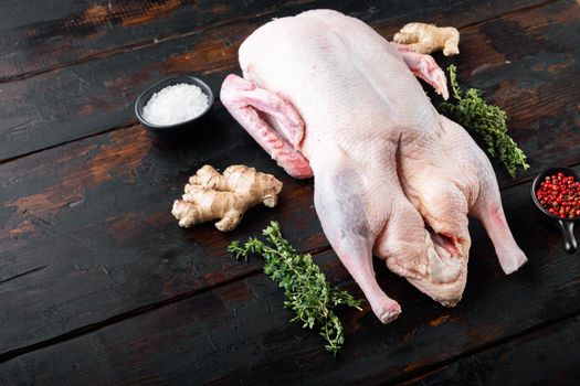 Fresh raw whole duck meat on old dark wooden table, with copy space.