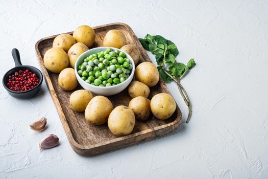 Mashed potatoes ingredient with green pea and mint, on white textured background with space for text