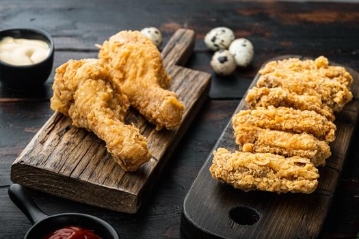 Southern fried chicken cuts on dark wooden background.