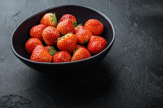 Ripe red strawberry with space for text, on black background.