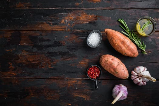 Raw whole sweet potatoe with herbs on old wooden table, flat lay with copyspace.