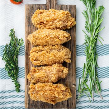 Fried chicken wings parts on white background, flat lay.