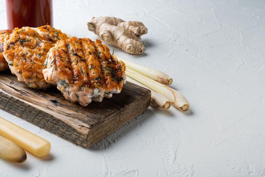 Cooked fish patties, with salmon and lemongrass, on white textured background