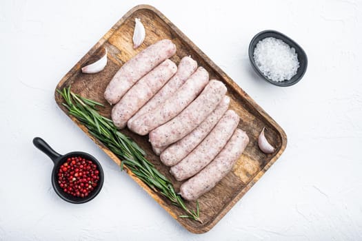 Homemade chicken meat sausages, top view, on white background.