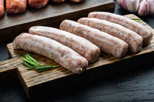 Traditional chicken sausages, on black background.