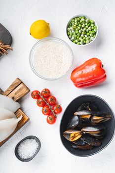 Fresh seafood assortment for paella on white textured background, flat lay, food photo.