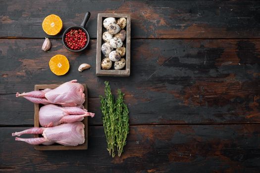 Homemade eco friendly raw quail, top view, on dark wooden background with copy space