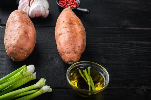 Sweet potato or batat with ingredients, on black wooden background with space for text.