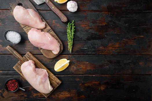 Crumbed uncooked chicken breasts ingredient, on dark wooden background, top view with space for text