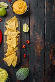 Triangular yellow corn tortilla chip with sauces, on old wooden table, top view or flat lay with copy space for text