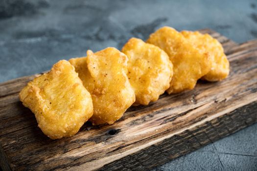 Chicken nuggets fried on grey background.