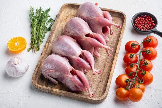 Fresh raw meat quail ready for cooking, on white textured background