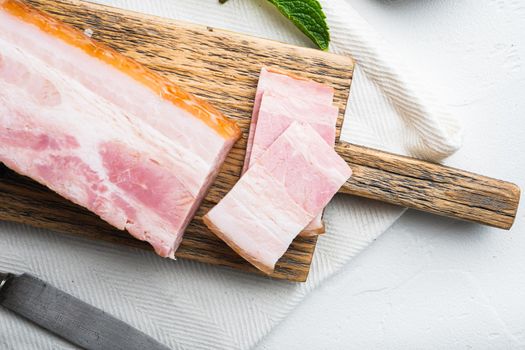 Bacon pancetta cut and sliced on white background.
