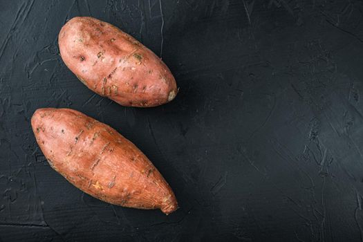 Sweet potato or batat on black background, top view with space for text.
