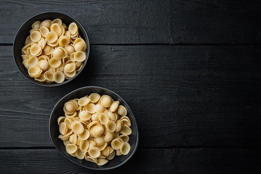 Durum wheat semolina pasta, on black wooden table, flat lay with copy space for text