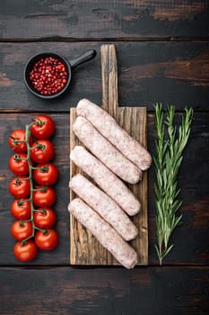 Traditional chicken sausages, top view, on old dark wooden background.