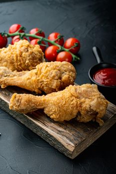 Breaded kentucky chicken drumctick parts on black background.