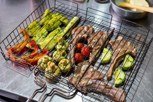 Ribs with meat and vegetables are prepared for grilling.