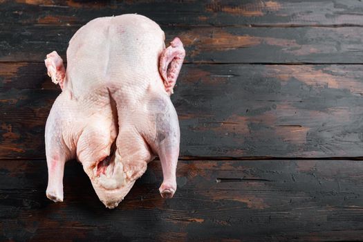Whole raw duck meat on dark wooden background, with space for text.
