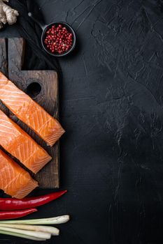 Fish patties ingredient with salmon and lemongrass, on black textured background, flat lay with space for text