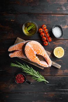 Slice of red fish salmon with herbs, on old wooden table, flat view.