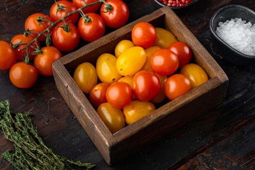 Mixed colour cherry tomatoes in wooden box, on old wooden table