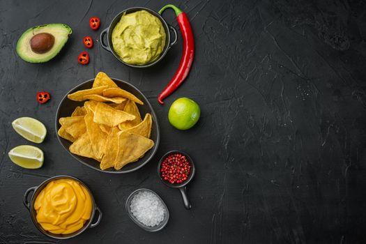 Mexican nachos chips with dip sauce, on black background, top view or flat lay with copy space for text