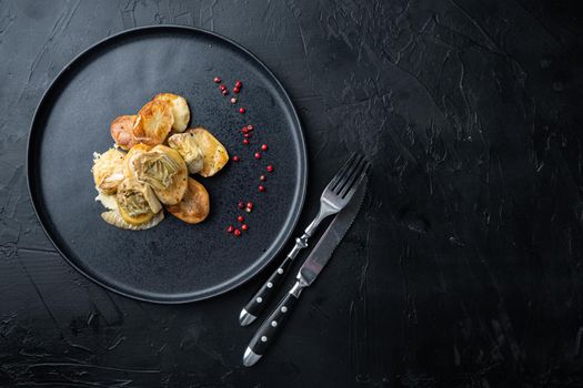 Baked potato, artichoke with fennel al forno, on black textured background, flat lay with space for text