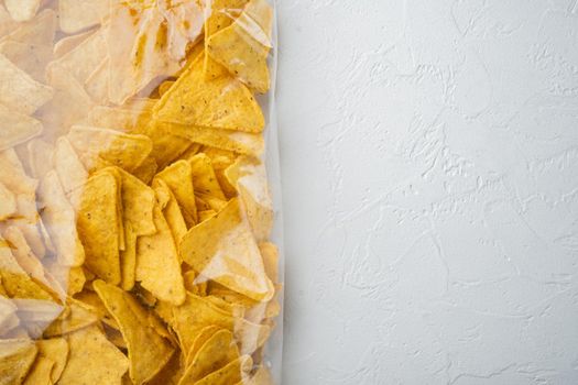 Tortilla Mexican nachos chips in plastic bag, on white background, top view or flat lay with copy space for text