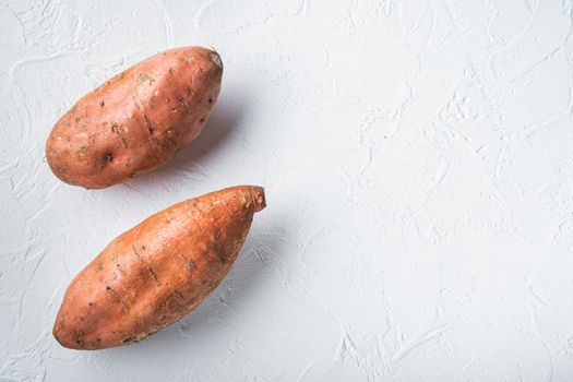 Raw whole sweet potatoe on white background, flat lay with copyspace.