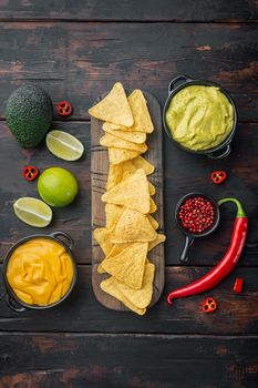 Nachos corn chips with traditional dip sauce set, on old wooden table, top view or flat lay