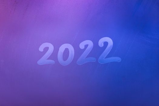 digit 2022 handwritten on wet night window glass surface, close-up with selective focus