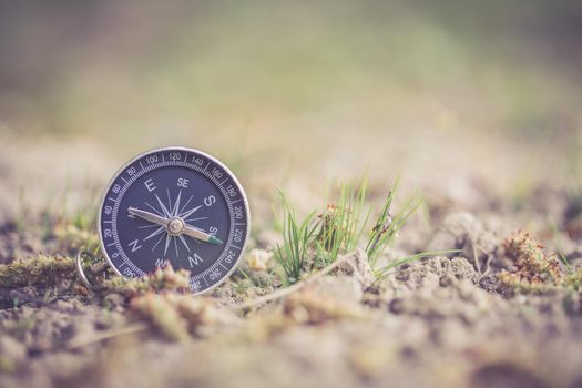 Vintage compass lying on the floor. Adventure and discovery concept.