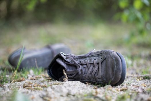 Dusty old shoe abandoned in the nature. Concept for missing.