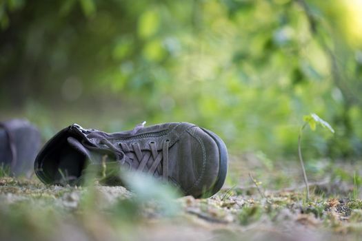 Dusty old shoe abandoned in the nature. Concept for missing.