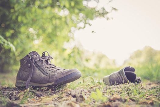 Dusty old shoe abandoned in the nature. Concept for missing.