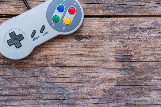 Retro computer gaming controller a rustic wooden background