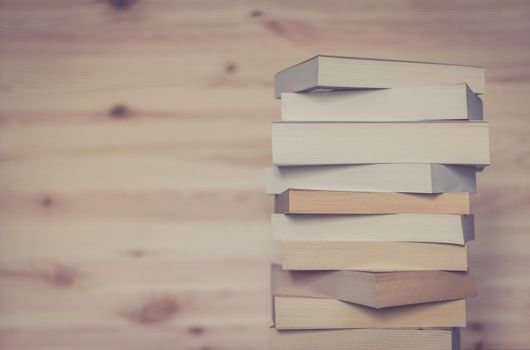 Stack of books on wooden background, knowledge and science