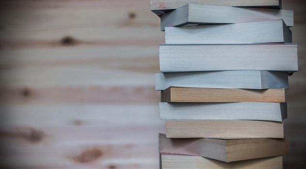 Stack of books on wooden background, knowledge and science