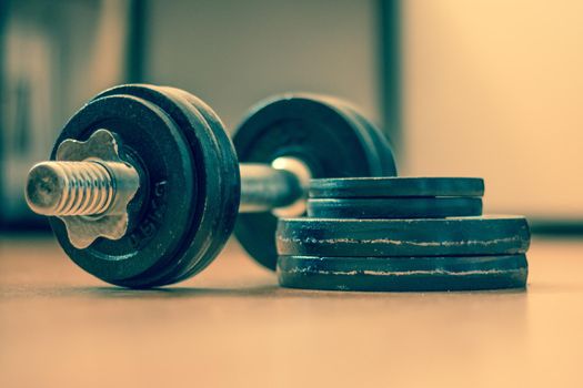 Black bar bell on the wooden floor, physical exercise