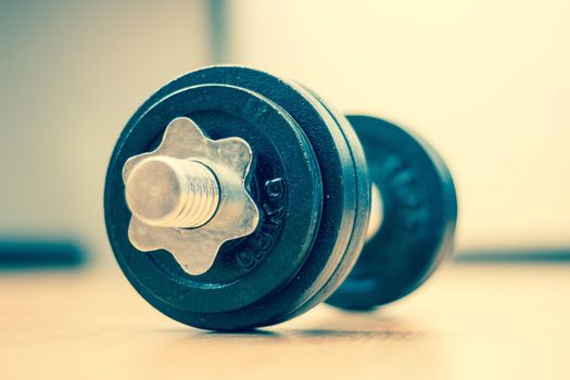 Black bar bell on the wooden floor, physical exercise
