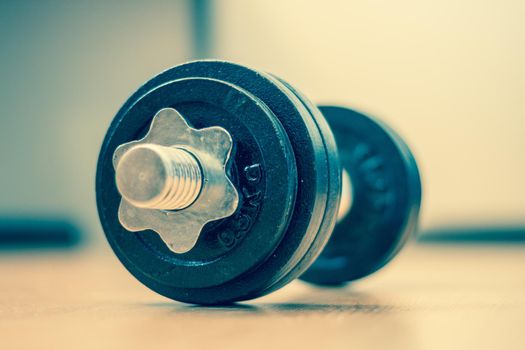 Black bar bell on the wooden floor, physical exercise