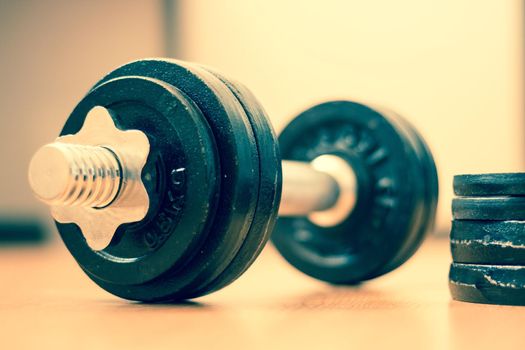 Black bar bell on the wooden floor, physical exercise