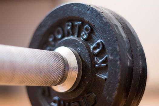 Black bar bell on the wooden floor, physical exercise
