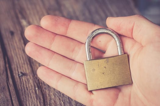 Padlock in the hand of a young man, close up